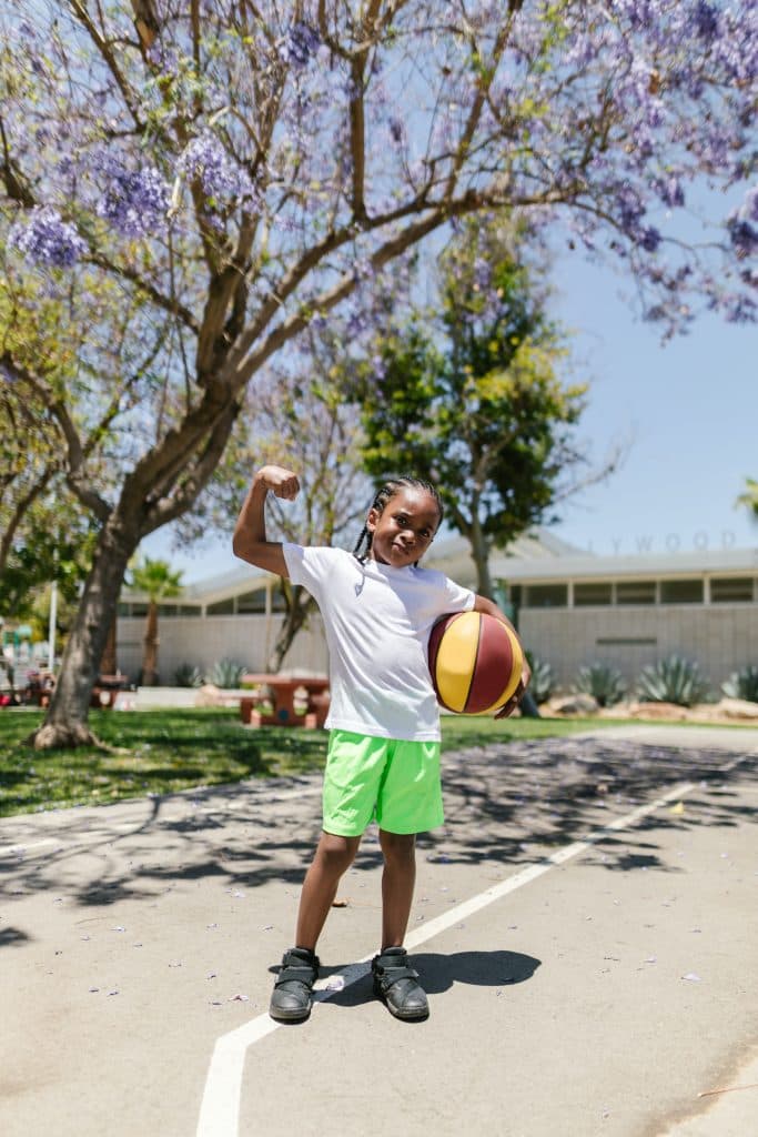 un enfant tient une balle de baskteball