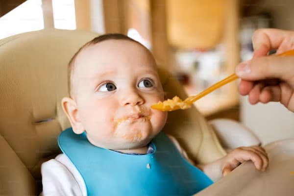 Un bébé semble ne pas aimer la purée qu'on lui donne