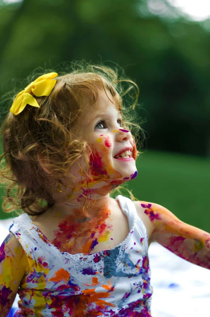 Une petite fille impulsive est recouverte de peinture