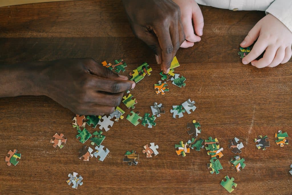 Image de puzzles et de mains d'adulte et d'enfant