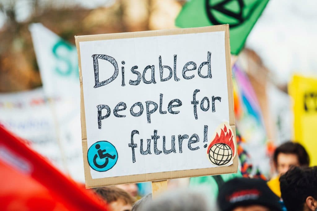 Sur un écriteau est écrit : disabled people for future. Ce qui signifie : les personnes en situation de handicap pour le futur.